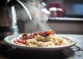A close-up of steaming rice with beans, captured in warm afternoon light.